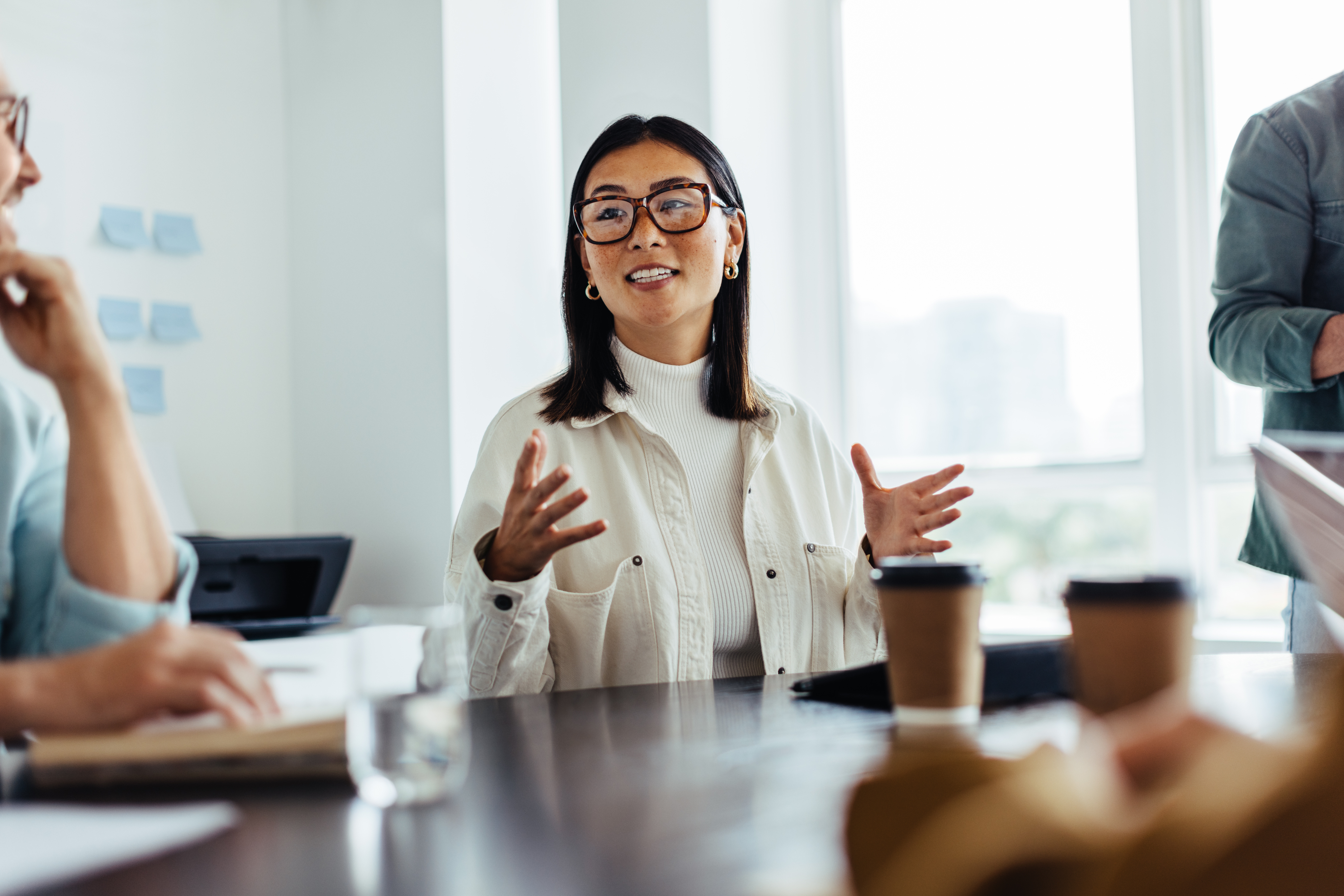 A woman in a meeting room gesturing calmly